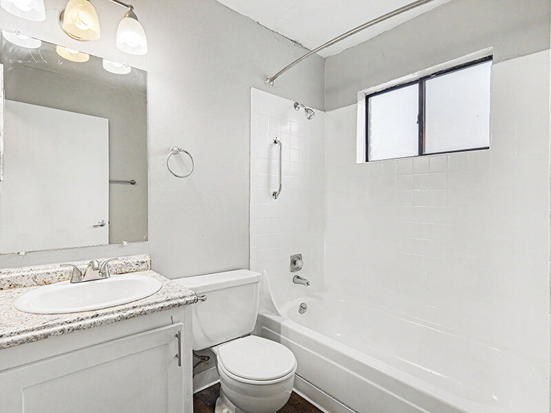 Apartment Bathroom with Window and Wood Styled Flooring and Mirror | Innovation at Fitz