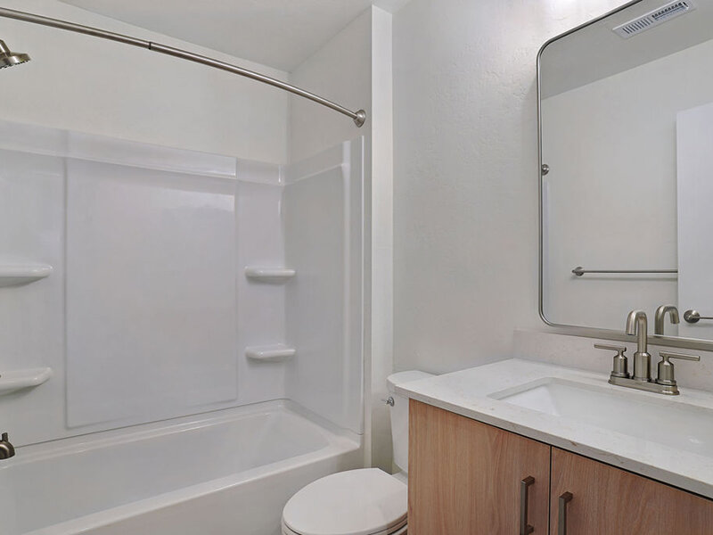 Bathroom with Wood Style Cabinets and Bathroom Mirror | Residences at J Ranch