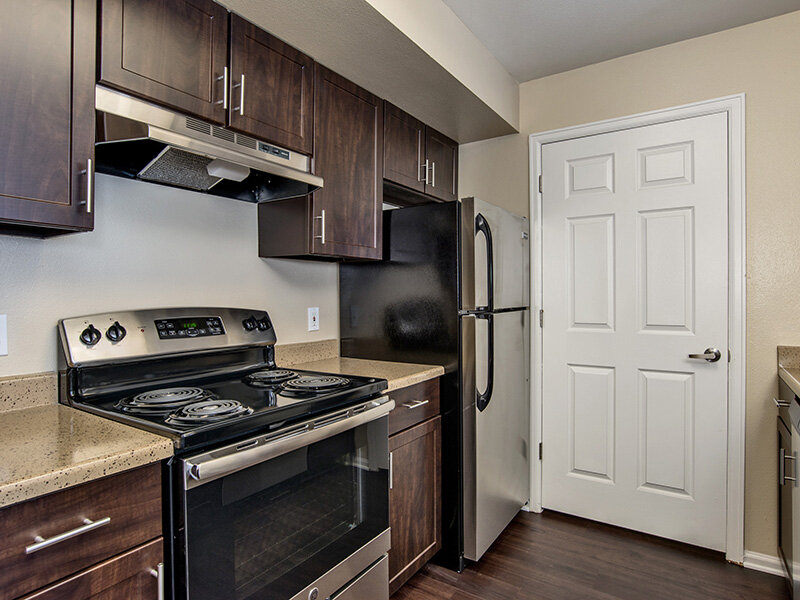 Refrigerator with Stove and Wood Style Cupboards and Flooring | The Bluffs at Castle Rock