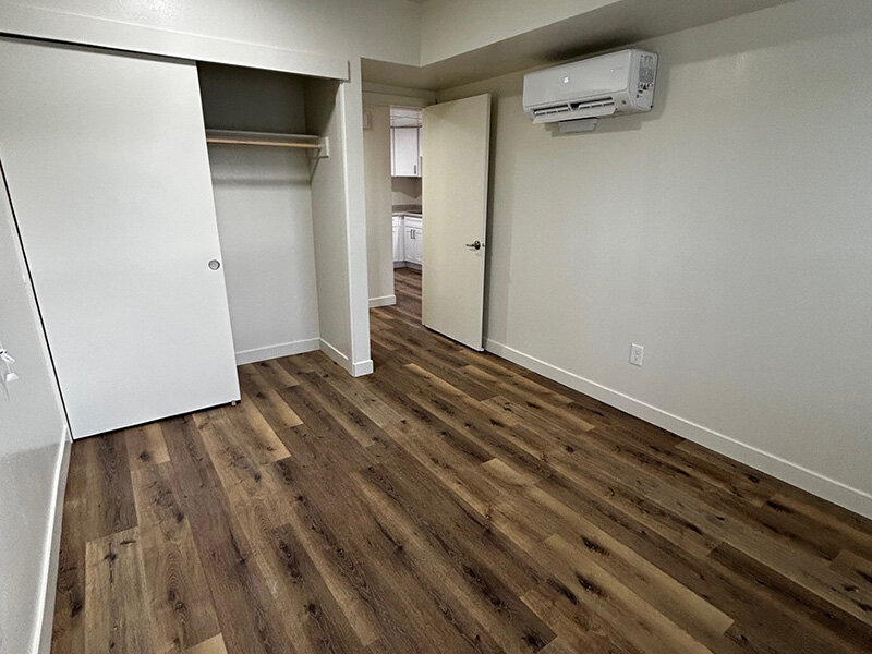 Bedroom with Open Closet and Wood Style Flooring | Riverside