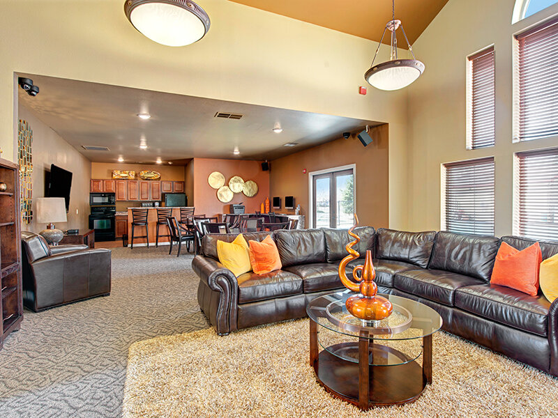 Community Room with Sofa Sectionals and Carpeted Flooring with Entrance to Community Kitchen | The Willows at Printers Park Apartments