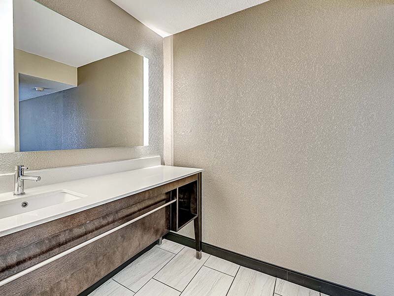Apartment Bathroom with Wood Style Cabinets and Mirror | Avia Lofts at Founders Road