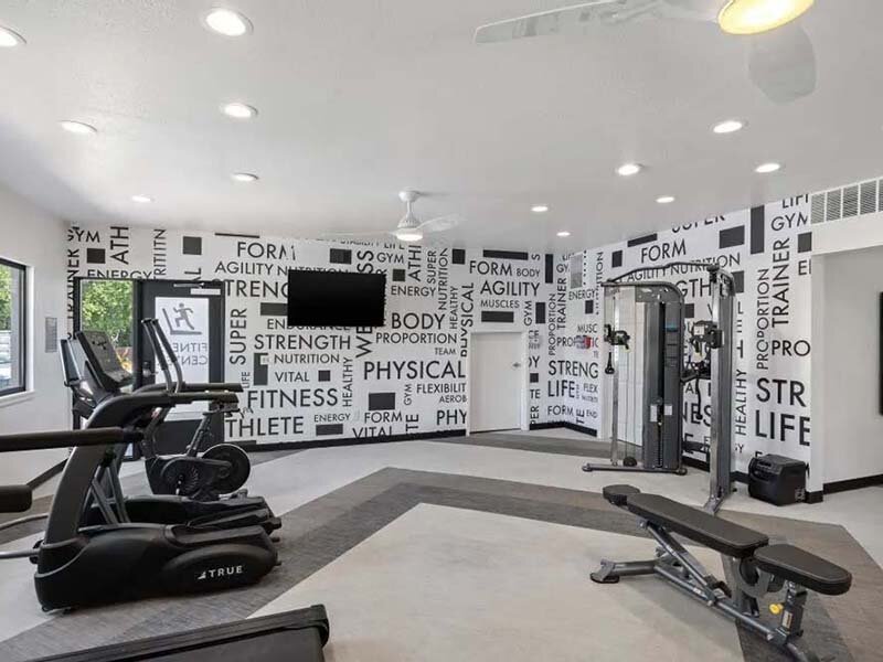 Community Fitness Center with Equipment and Television and Ceiling Lights | Avia on College Boulevard