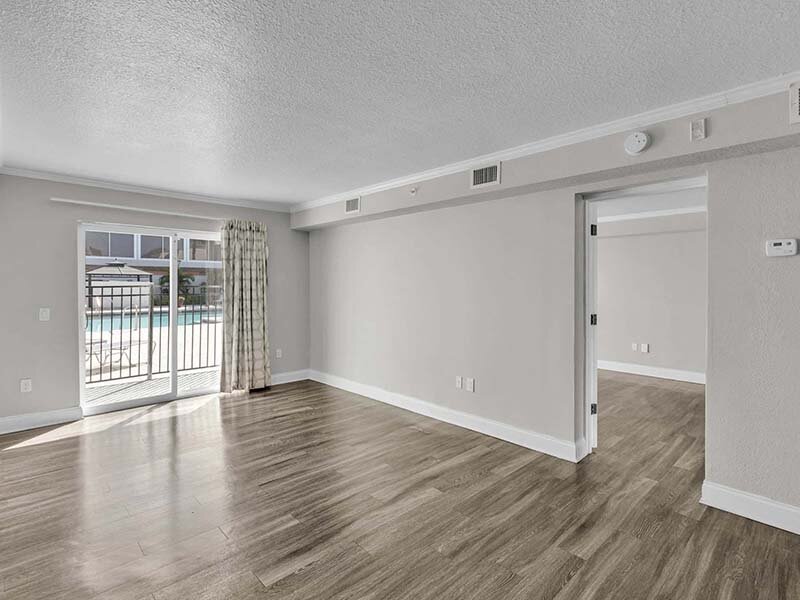 Apartment Room with Wood Style Flooring and View of Outdoor Pool | Avia At Reedy Creek