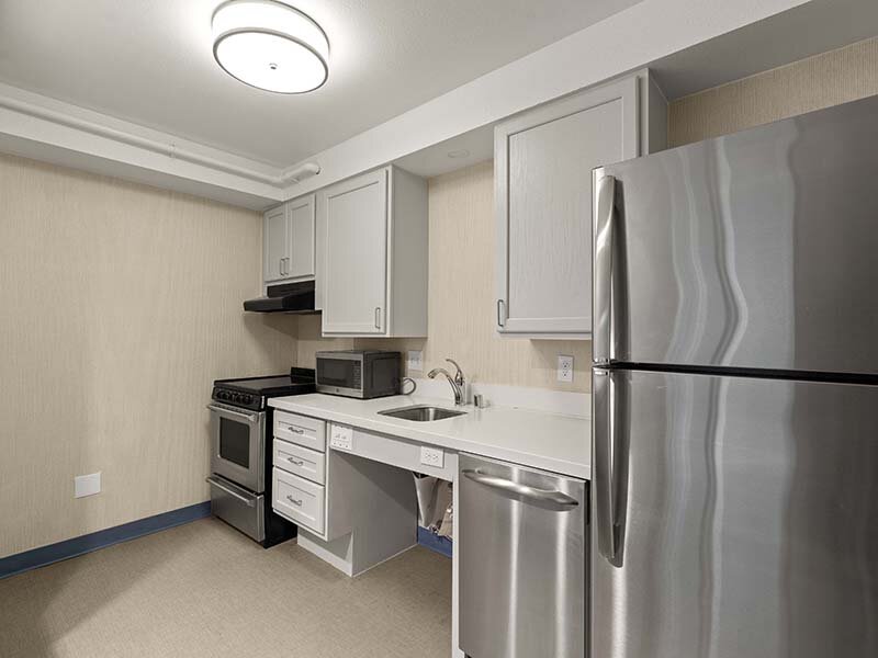 Apartment Kitchen with Refrigerator and Wood Style Flooring | Avia Lofts on Parkway