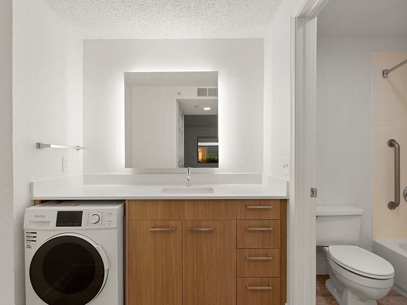 Bathroom with Wood Styled Cabinets and Laundry | Avia Lofts on Parkway