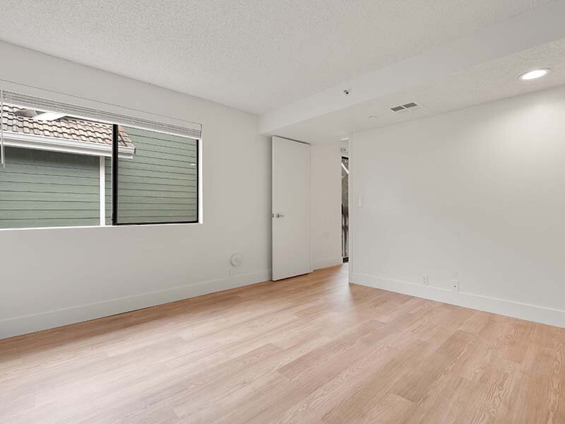 Bedroom with Open Door and Wood Styled Flooring | Avia Lofts on Parkway