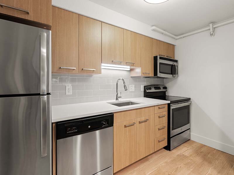 Apartment Interior Kitchen with Appliances and Wood Style Flooring | Avia Lofts on Parkway