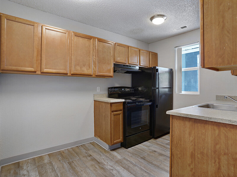 Kitchen with Black Appliances and Brown Cabinetry | Sienna Place