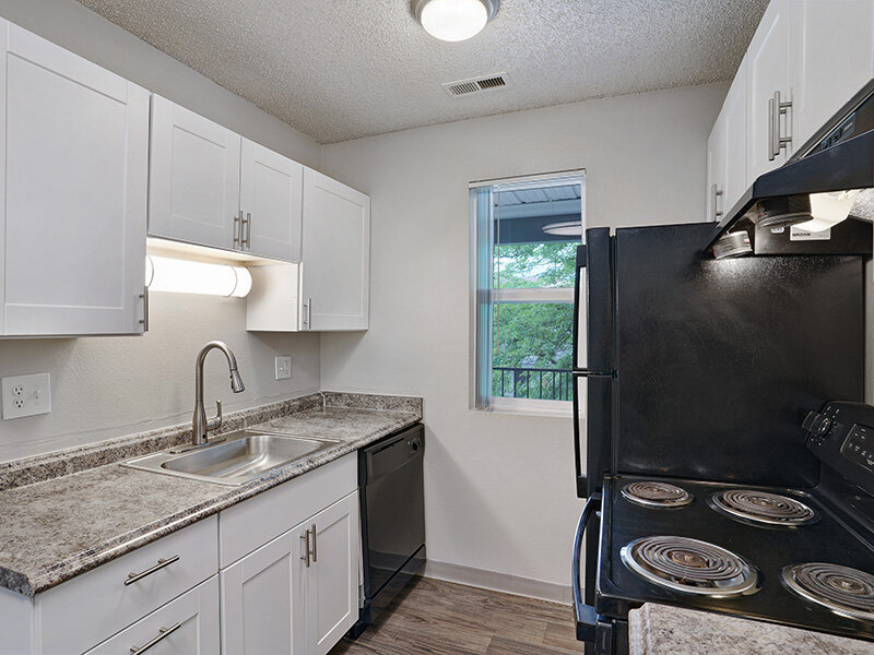 Kitchen with Black Appliances and White Cabinetry | Sienna Place