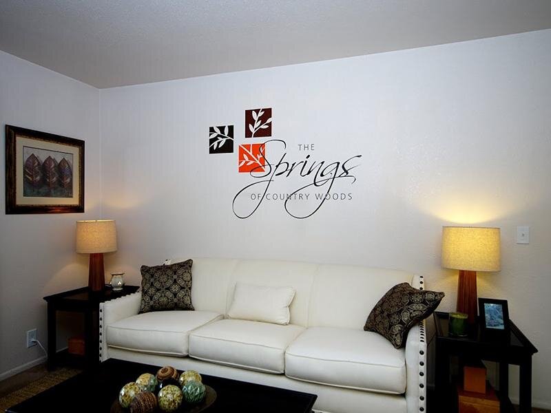 Springs of Country Woods logo over Couch