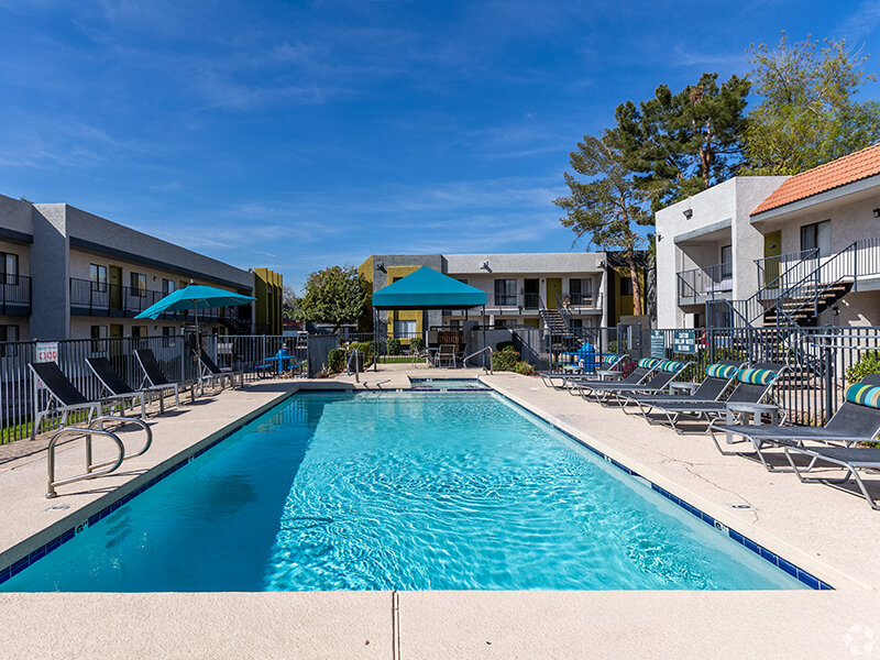 Apartment Outdoor Pool with Stone Style Flooring and Patio Umbrella's | Emerson Square