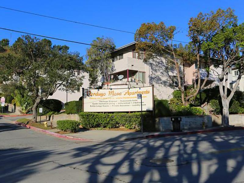 Apartments for Rent in Los Angeles, CA - Verdugo Mesa - Building Exterior with Property Sign, Street Access, and Lush Landscaping