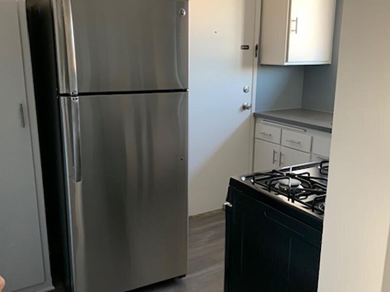 Los Angeles, CA Apartments for Rent - Verdugo Mesa - Kitchen with Stainless-Steel Refrigerator, Counter Space, and White Cabinets
