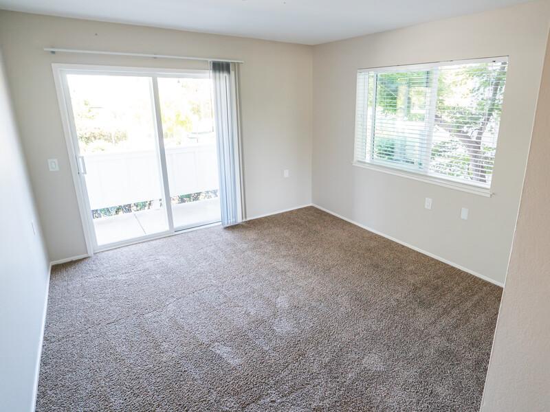 Two BR Apartments in San Rafael CA - McInnis Park - Empty Bedroom with Carpet, Window, and Sliding Glass Door Leading to Patio/Balcony.