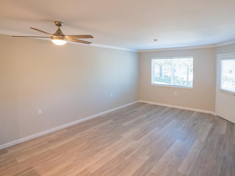 Apartments for Rent in San Rafael CA - McInnis Park - Living Room with Wood-Style Flooring, Windows, and Ceiling Fan.