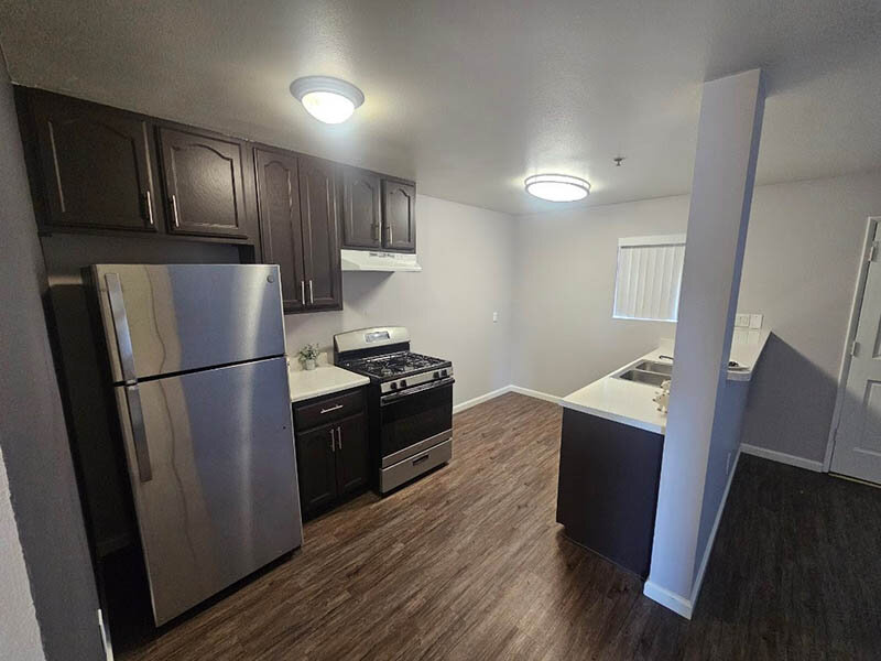 Kitchen Appliances with Wood Style Flooring and Kitchen Sink | The Grand at 5746