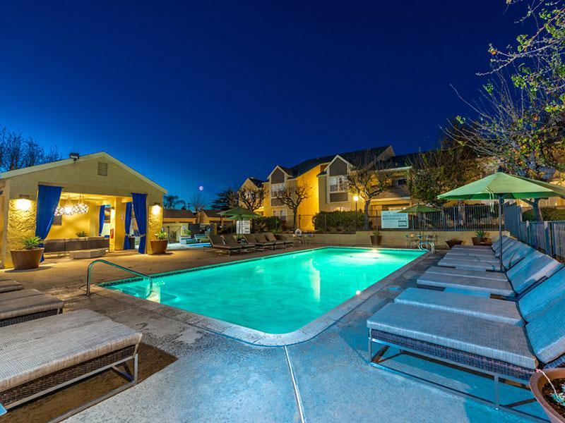 Apartments For Rent in Upland, CA - Parc Claremont - Gated Swimming Pool with Outdoor Lounge Seating and View of Clubhouse Near Hot Tub