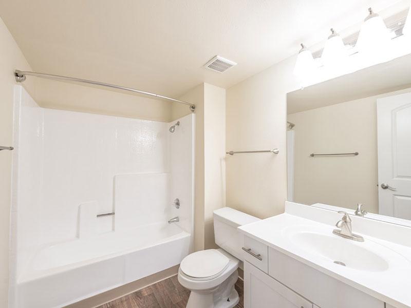 Apartments For Rent in Upland - Parc Claremont - Bathroom with Upgraded Countertops, Wood-Style Flooring, and Full Tub