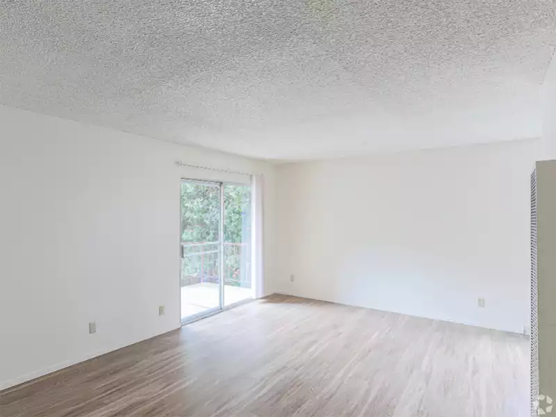 Apartments In Berkeley For Rent - Living Room Area With Wood-Style Floors, Balcony Area, And White Walls