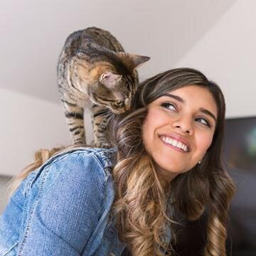 cat perched on womans shoulder