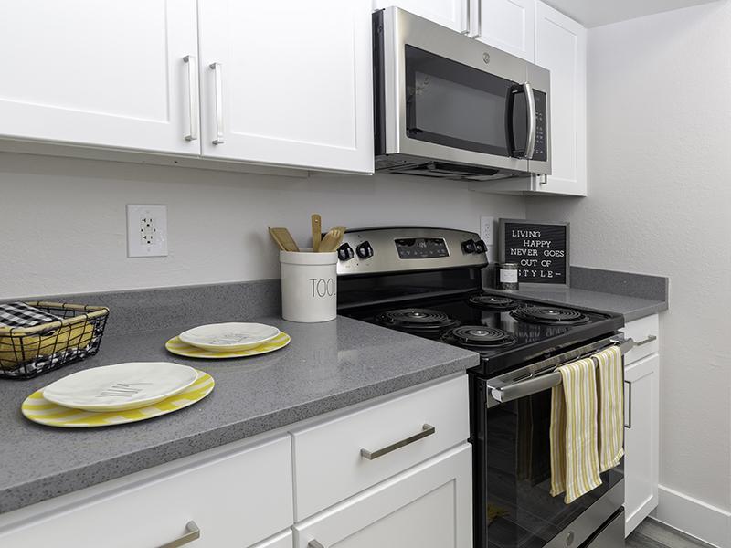 Salt Lake City Apartments - Foothill Place - Kitchen with Granite-Style Counter Space, Kitchen Utensils, and Stainless-Steel Appliances