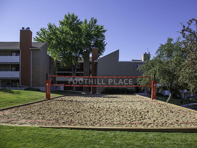 Dog Friendly Apartments in Salt Lake City, UT - Foothill Place Apartments Outdoor Sand Volleyball Court Surrounded by Trees and Well-Manicured Lawn