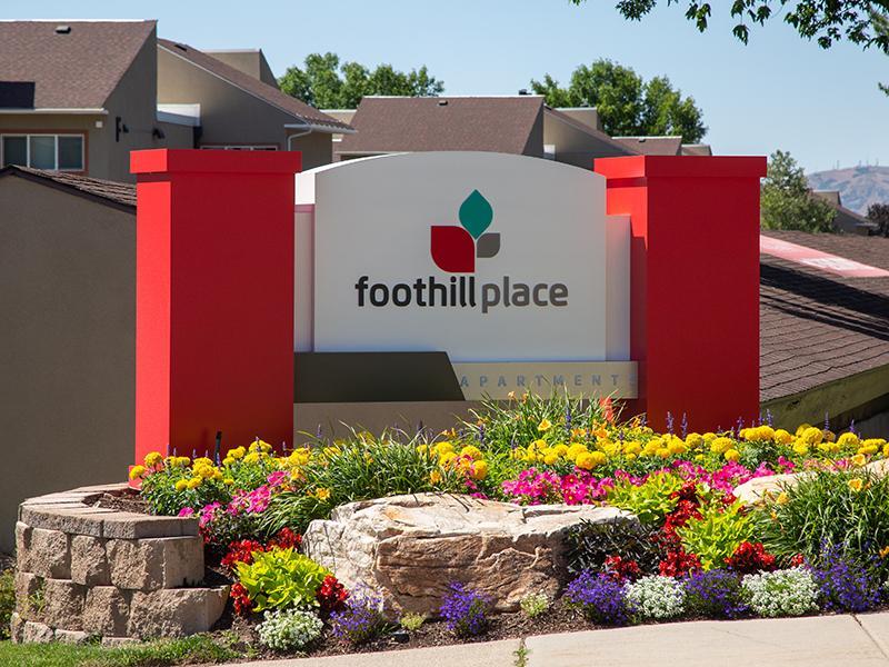 Pet-Friendly Apartments in Salt Lake City, UT - Foothill Place Apartments Front Sign with Lush Landscaping and Clubhouse
