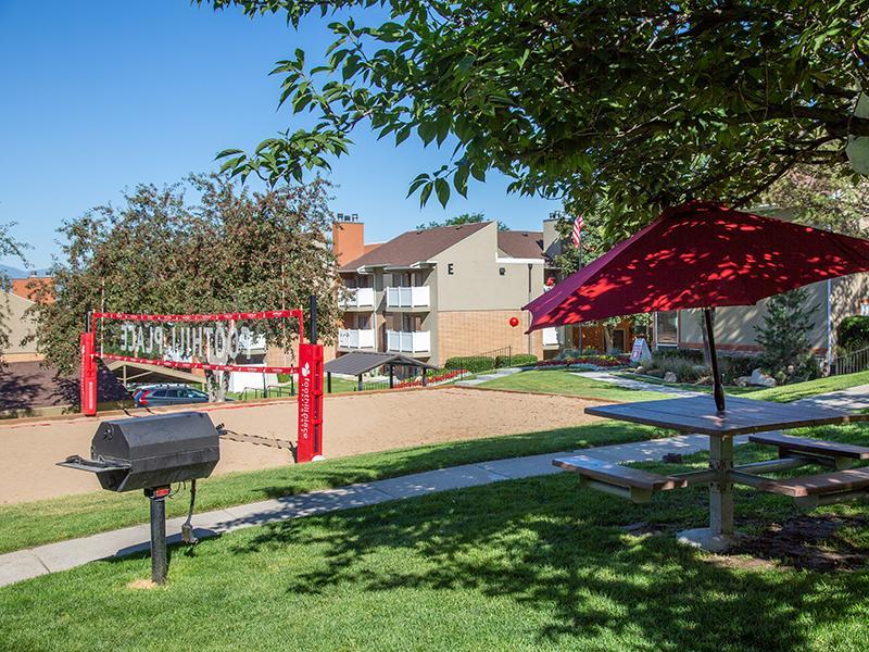 Salt Lake City UT Apartments - Foothill Place - Outdoor Courtyard with a Volleyball Court, Picnic Tables, and a Grill Area