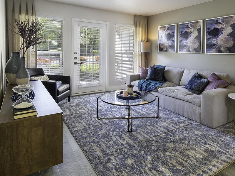 Taylorsville, UT Apartments - Maison's Landing Living Room with Wood-Style Flooring and Access to Patio or Balcony