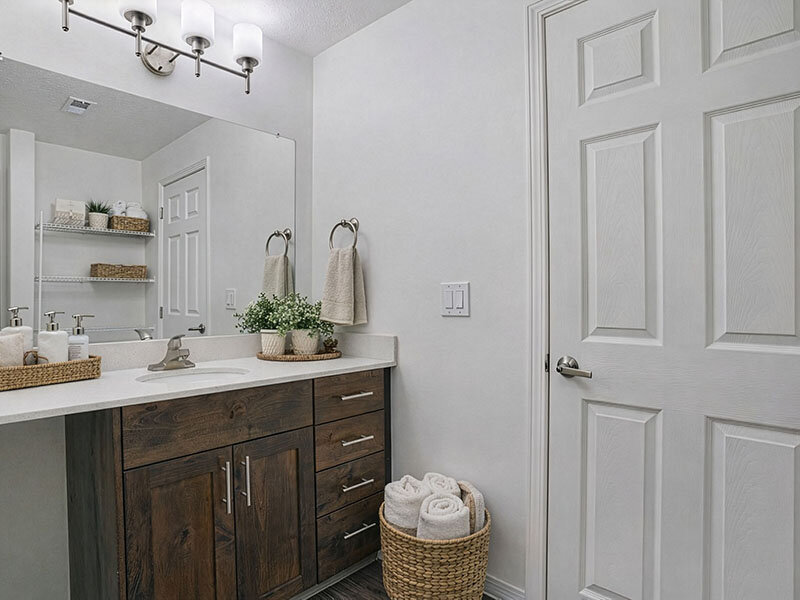 Bathroom with Wood Style Cupboards and Bathroom Mirror | Wasatch Commons