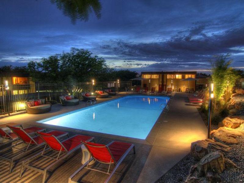 Holladay, UT Apartments - Sandpiper - Sparkling Pool At Dusk With Poolside Seating and Gated Entry