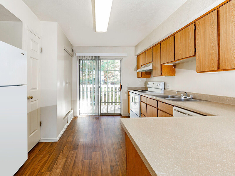 Kitchen with Wood Style Cabinets and Flooring with Patio Entrance | Woods Crossing