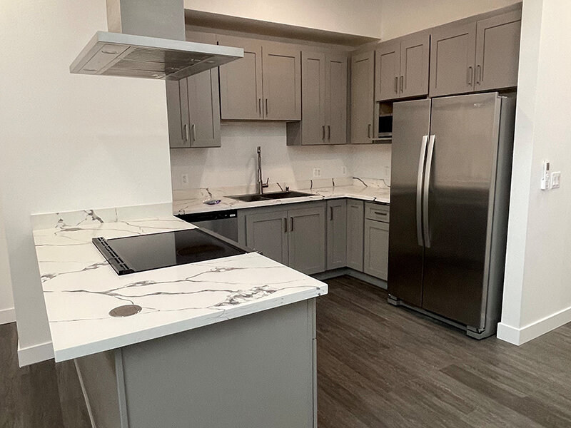 Marble Styled Countertop with Kitchen Cupboards and Refrigerator | Pacific Place Apartments