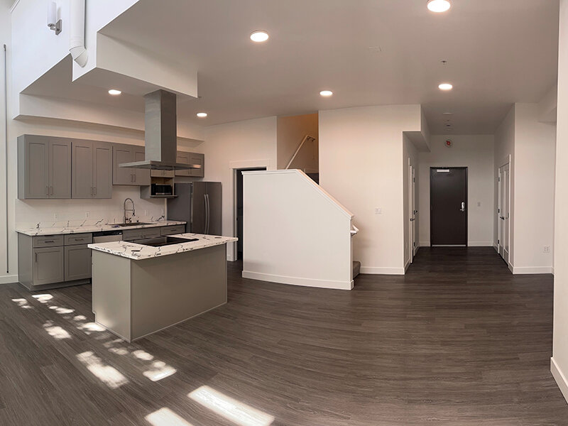 Kitchen with Marble Style Countertop and Wood Style Flooring with Staircase | Pacific Place Apartments
