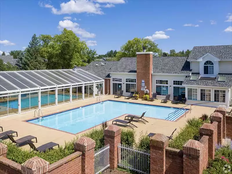 Naperville Apartments - Arbors of Brookdale - Pool with Lounge Chairs, Greenery, and Access to Clubhouse