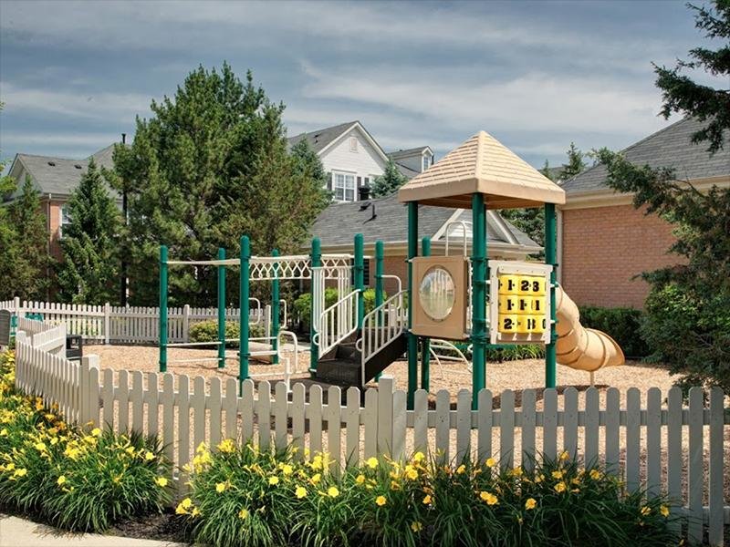 Naperville Apartments - River Run at Naperville- Playground Set with a Slide Inside a Fenced Area