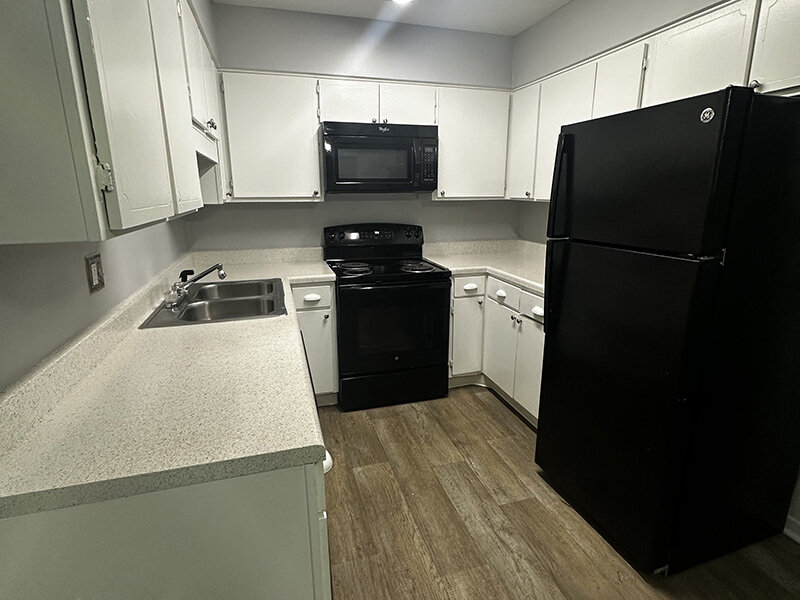 Kitchen with Wood Style Flooring and Kitchen Appliances | Ashland Commons Apartments