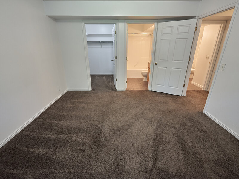 Apartment Bedroom with Entrance to Closet and Bathroom with Carpeted Flooring | Autumn Hills Apartments