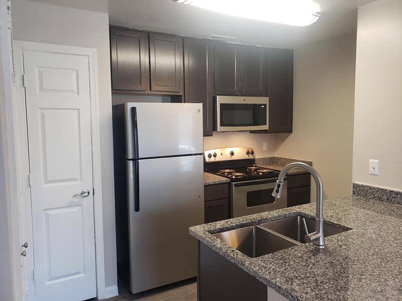 Model kitchen with stainless steel appliances and pantry at Bridgewater at Town Center Apartments.