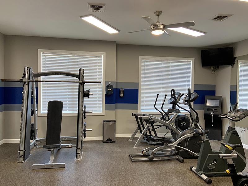 Fitness Center furnished with weight machines and dumbbells at Bridgewater at Town Center Apartments in Hampton. 