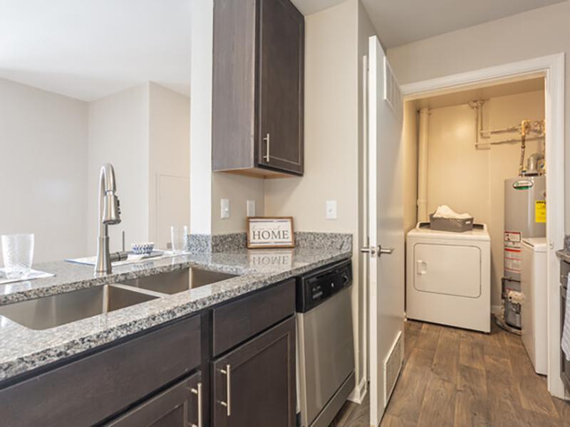 Galley kitchen with a double sink and attached laundry room at Bridgewater at Town Center Apartments in Hampton