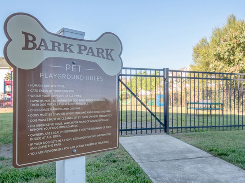 Fenced in bark park with a bench and agility stations for your dog at Bridgewater at Town Center Apartments in Hampton.