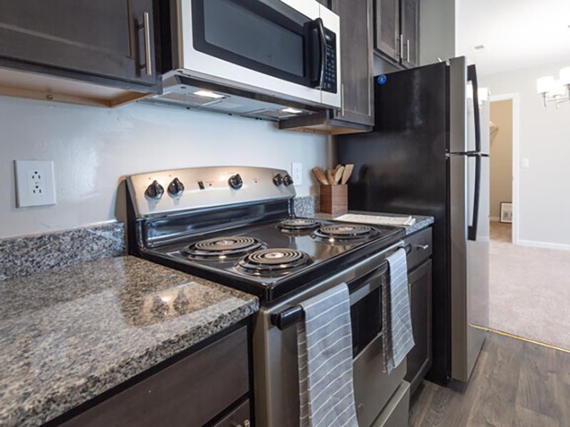 Model kitchen with stainless steel appliances and granite-style countertops at Bridgewater at Town Center Apartments.