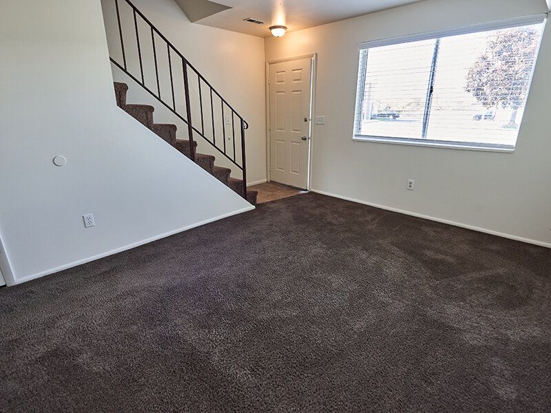 Apartment Living Room with Window and Staircase | Kaysville Country Townhomes