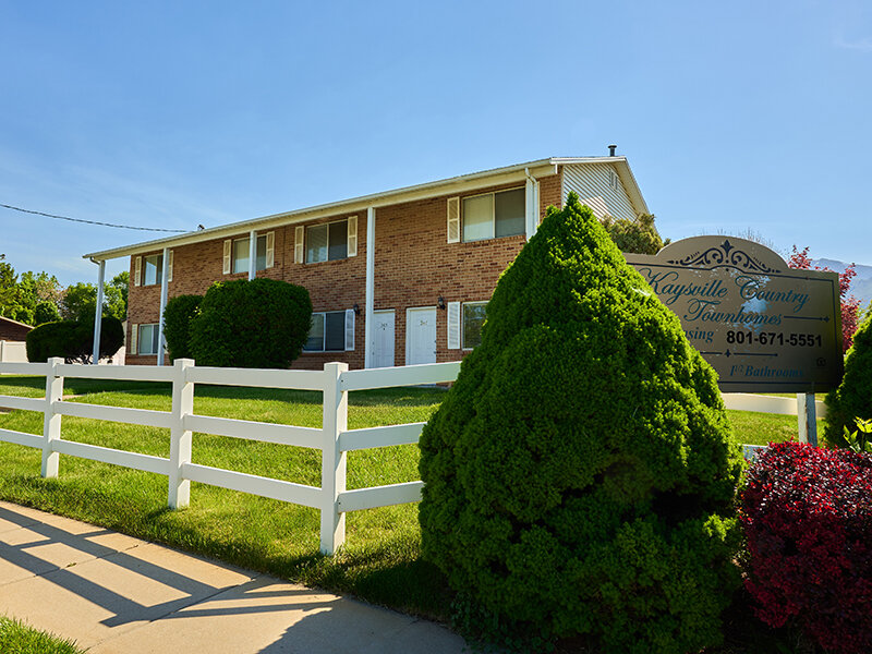 Outdoor View of Apartment Complex with Fence and Foliage | Kaysville Country Townhomes