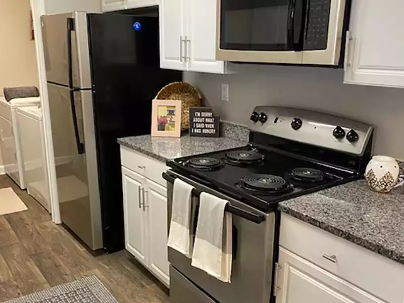 The kitchens at The Lakes at Town Center Apartments in Hampton have wood-style flooring and stainless steel appliances