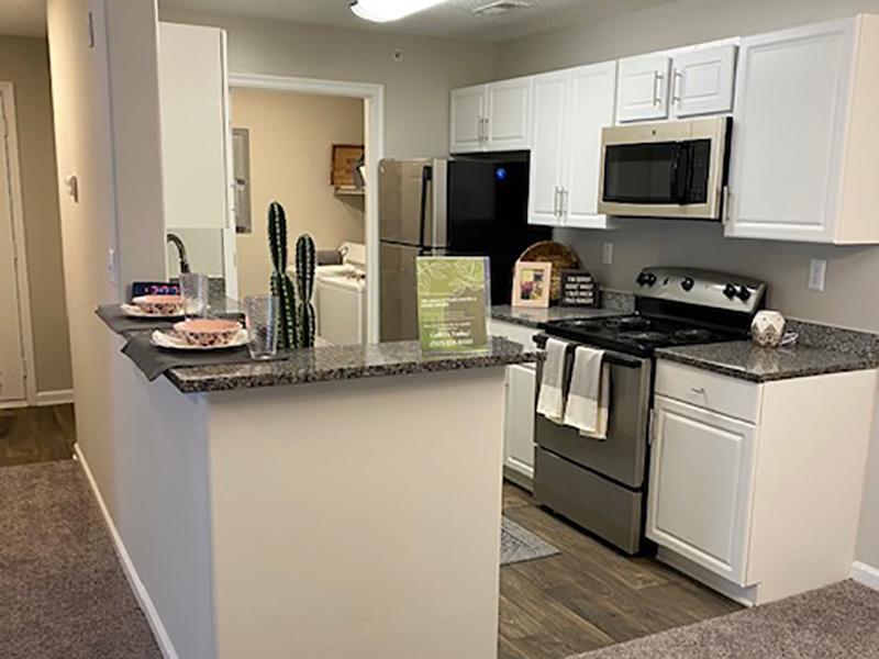 Model kitchen with stainless steel appliances and attached laundry room at The Lakes at Town Center Apartments