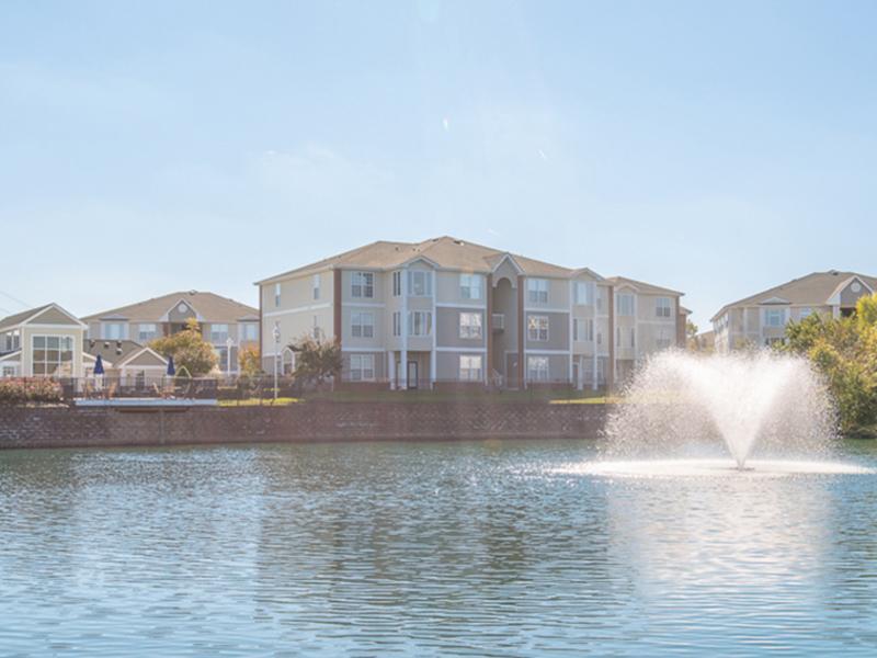 Looking over the community lake with a fountain towards the apartment buildings at The Lakes at Town Center.