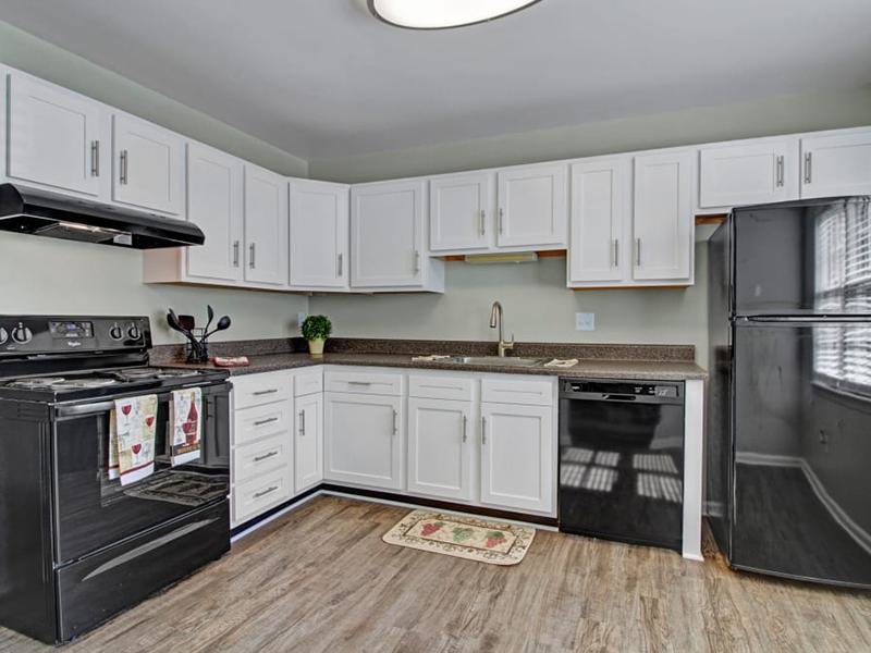 Kitchens feature wood-style flooring and stainless steel appliances at Tech Center Apartments.